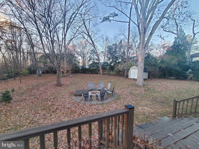 view of yard featuring a storage shed and a fire pit