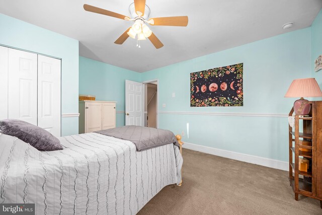 carpeted bedroom featuring ceiling fan and a closet