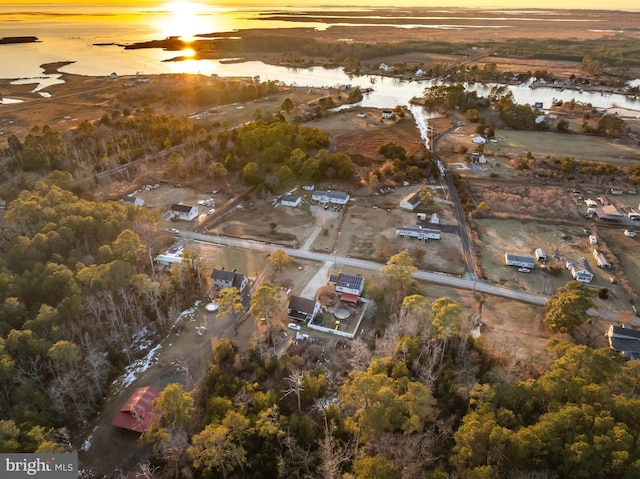 aerial view at dusk featuring a water view