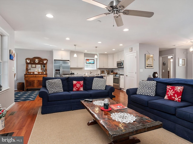 living room featuring light hardwood / wood-style floors and ceiling fan