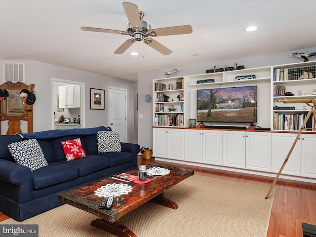 living room with light hardwood / wood-style floors and ceiling fan