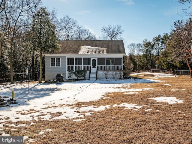 snow covered back of property with covered porch