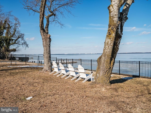 dock area with a water view and a yard