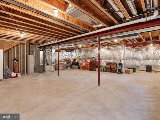 basement featuring heating unit, white refrigerator, and water heater