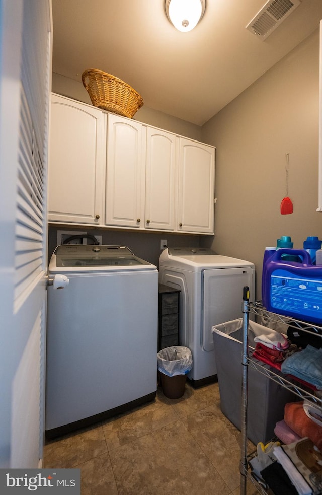 washroom with washer and clothes dryer and cabinets