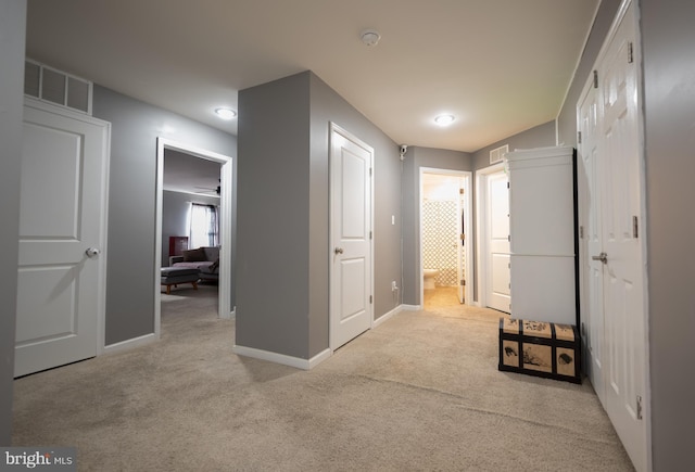 hallway featuring light colored carpet