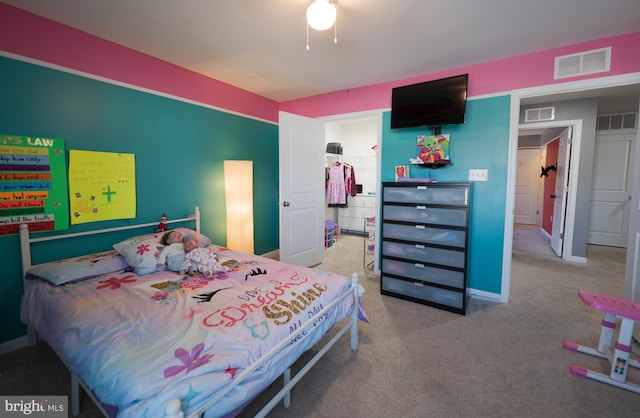 carpeted bedroom with ceiling fan, a spacious closet, and a closet