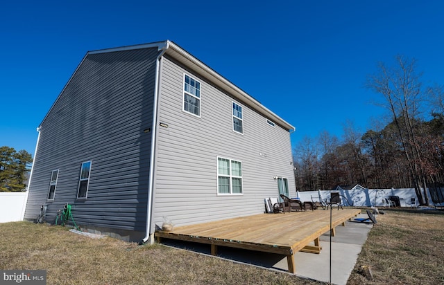 rear view of house with a yard and a deck