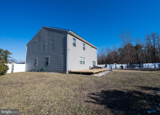 view of property exterior featuring a wooden deck and a lawn