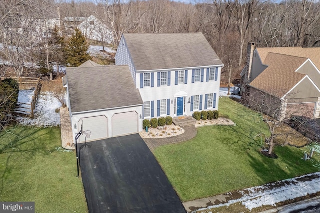 view of front of home with a garage and a front lawn