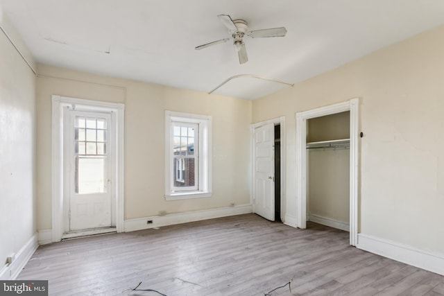 unfurnished bedroom with two closets, light hardwood / wood-style flooring, and ceiling fan