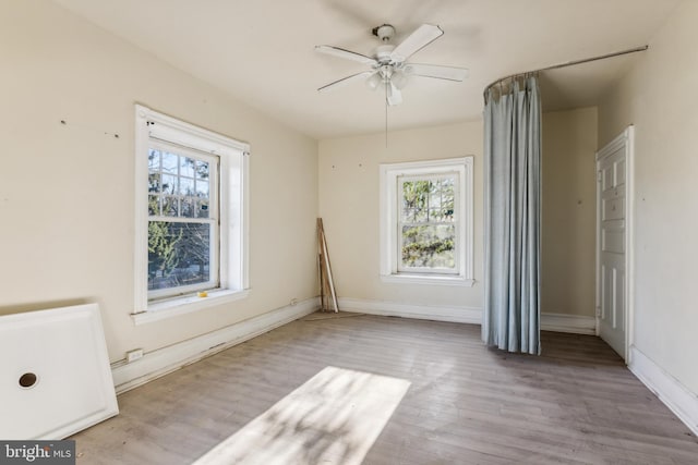 unfurnished room with ceiling fan and light wood-type flooring