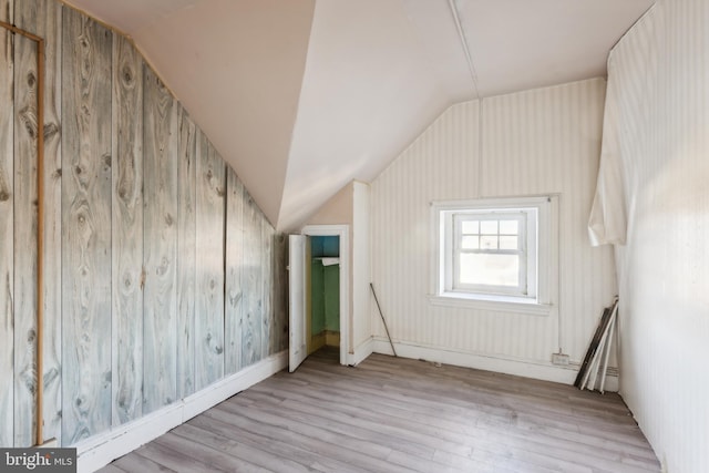 bonus room with vaulted ceiling and light hardwood / wood-style flooring