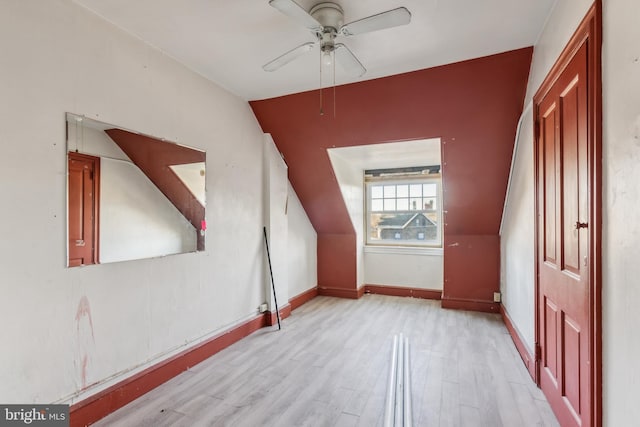 additional living space featuring ceiling fan, vaulted ceiling, and light wood-type flooring