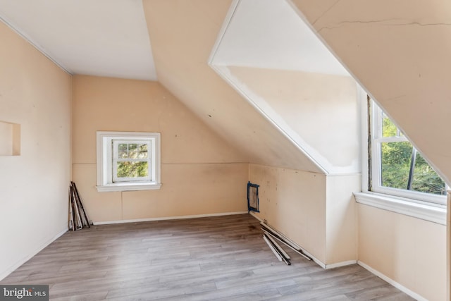 bonus room featuring lofted ceiling and light hardwood / wood-style flooring