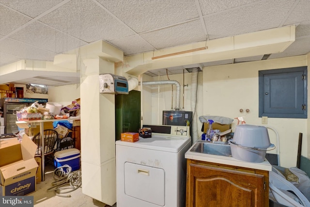 clothes washing area featuring water heater, washer / dryer, and electric panel