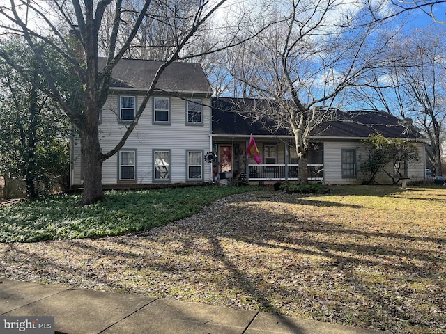 view of front of home with covered porch and a front lawn