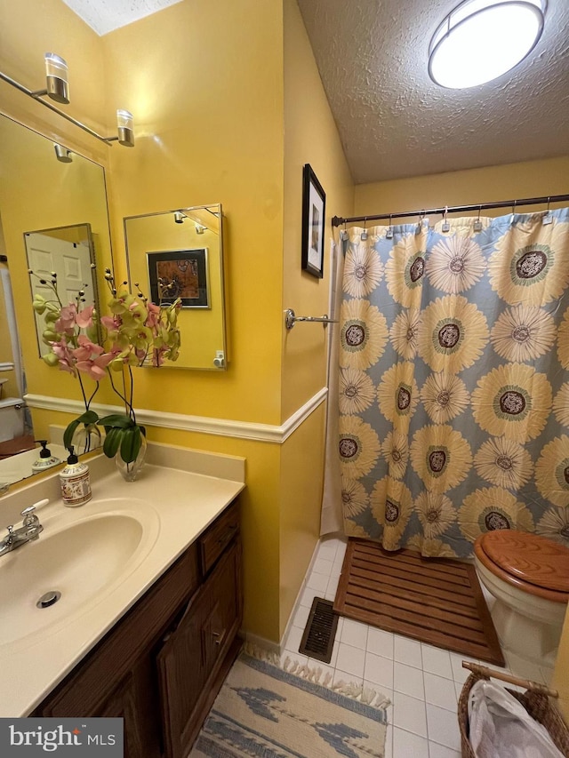full bath featuring a textured ceiling, visible vents, and tile patterned flooring
