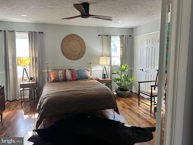 bedroom featuring hardwood / wood-style flooring, ceiling fan, and a textured ceiling