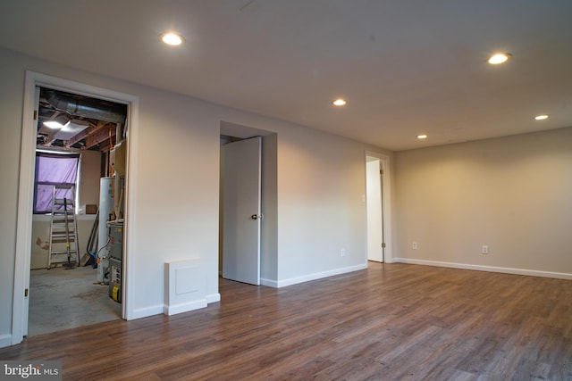 spare room featuring dark hardwood / wood-style flooring and gas water heater