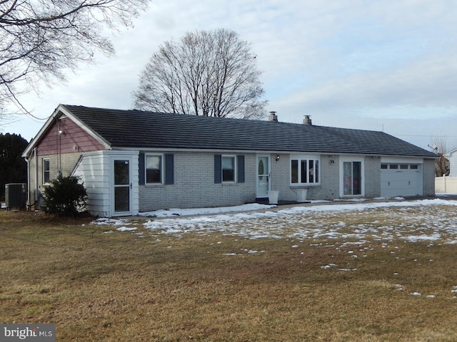 ranch-style house with a garage, central AC, and a lawn