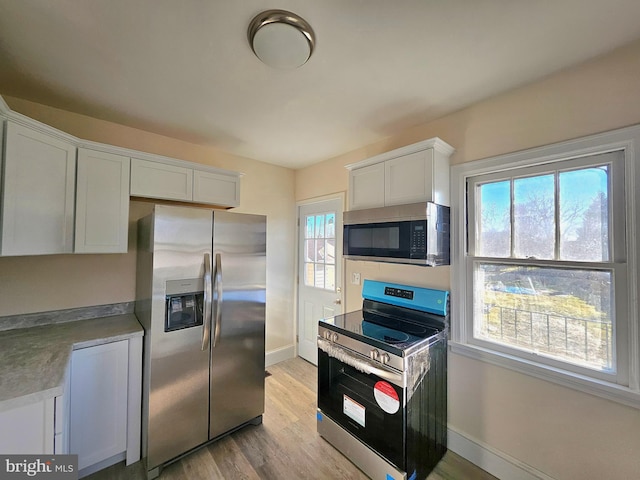 kitchen featuring white cabinetry, light hardwood / wood-style floors, and appliances with stainless steel finishes