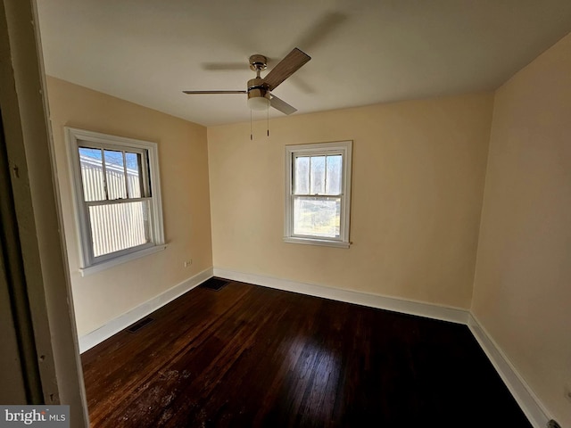 unfurnished room featuring dark wood-type flooring and ceiling fan