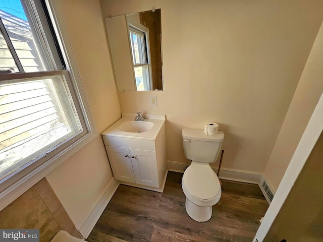 bathroom featuring hardwood / wood-style flooring, vanity, plenty of natural light, and toilet