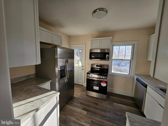 kitchen featuring white cabinetry, dark wood-type flooring, and stainless steel appliances