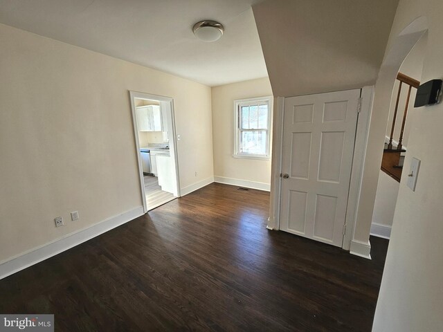 empty room with dark hardwood / wood-style floors