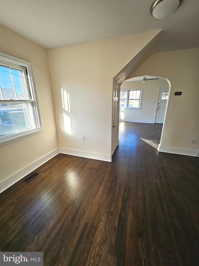 empty room with dark hardwood / wood-style floors and ceiling fan