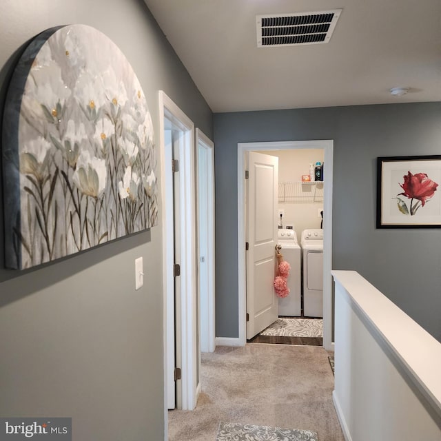 corridor with light carpet and washing machine and dryer