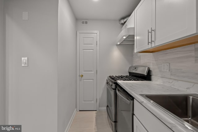 kitchen with stainless steel appliances, white cabinetry, decorative backsplash, and range hood