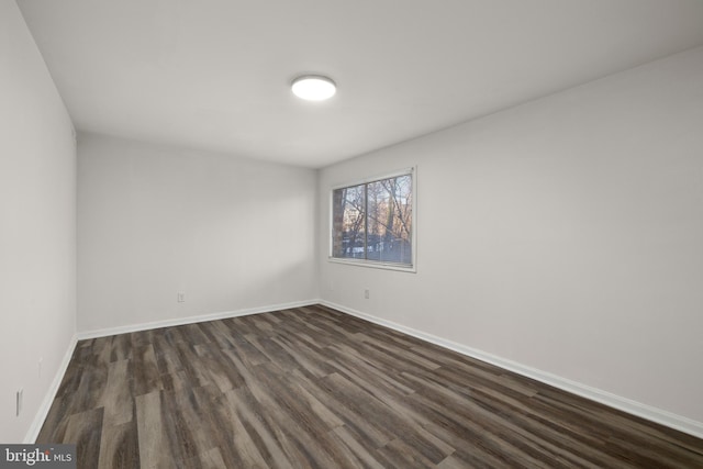 spare room with dark hardwood / wood-style floors