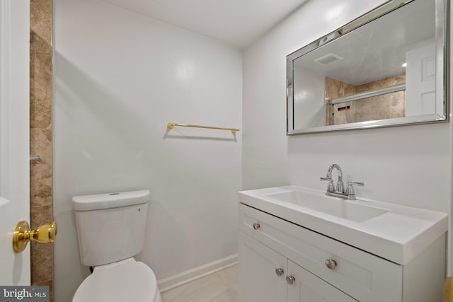 bathroom featuring vanity, tile patterned flooring, a shower with door, and toilet