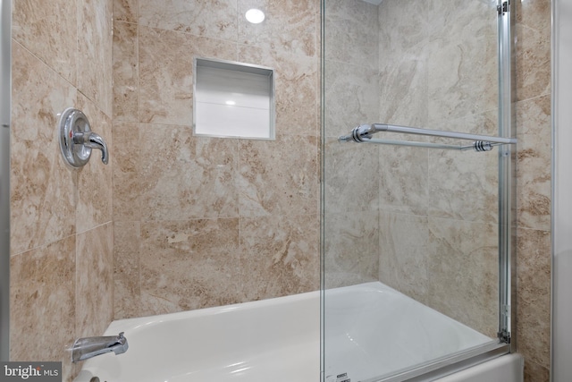 bathroom featuring bath / shower combo with glass door