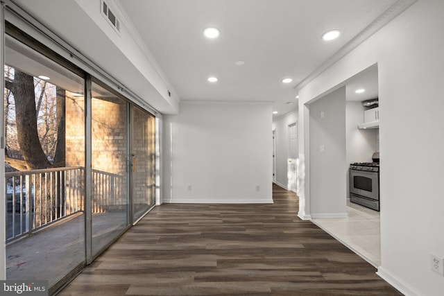 interior space featuring ornamental molding, a healthy amount of sunlight, and dark hardwood / wood-style floors