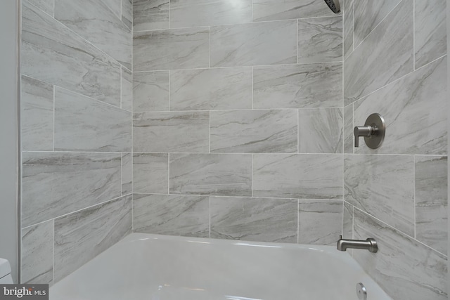 bathroom featuring tiled shower / bath