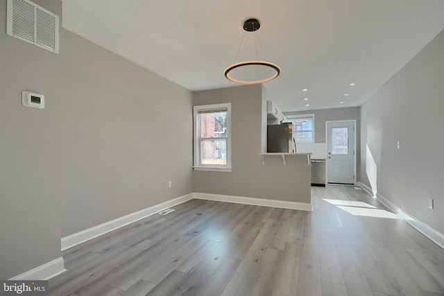 unfurnished living room featuring light hardwood / wood-style flooring and a healthy amount of sunlight