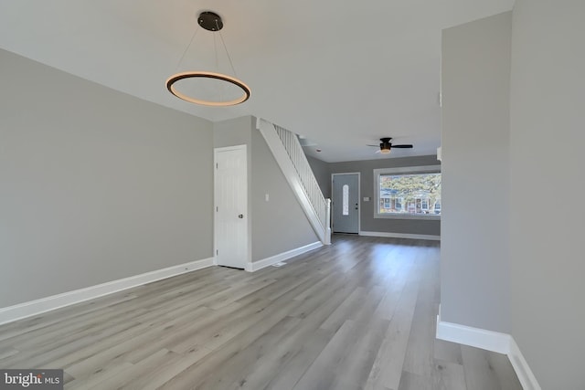 unfurnished living room featuring ceiling fan and light wood-type flooring