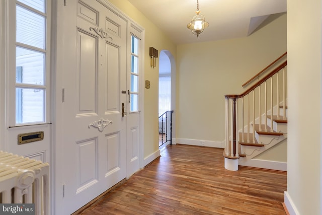 foyer entrance with wood-type flooring and radiator