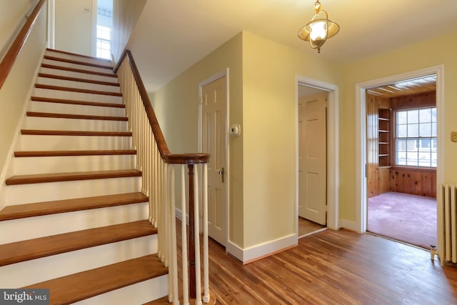 stairs featuring radiator and hardwood / wood-style floors