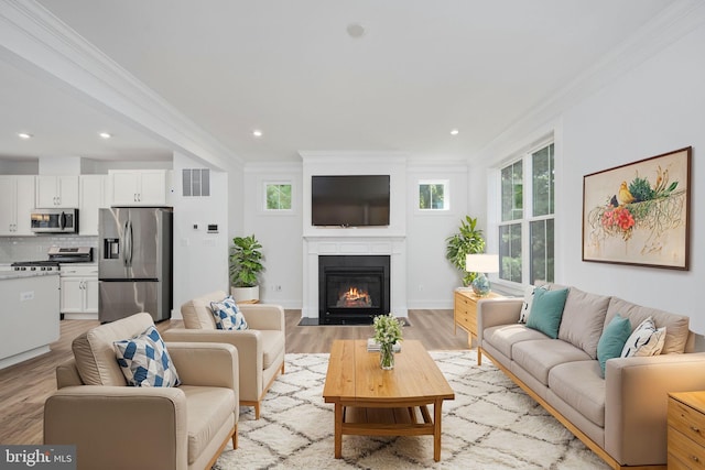 living room with light hardwood / wood-style flooring and ornamental molding