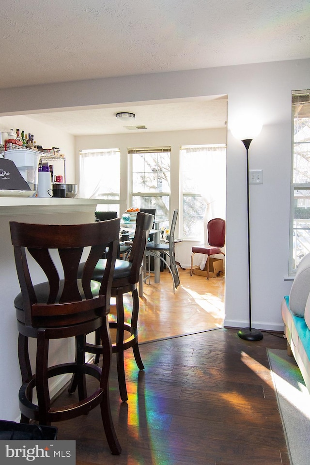 dining area with hardwood / wood-style floors and a textured ceiling