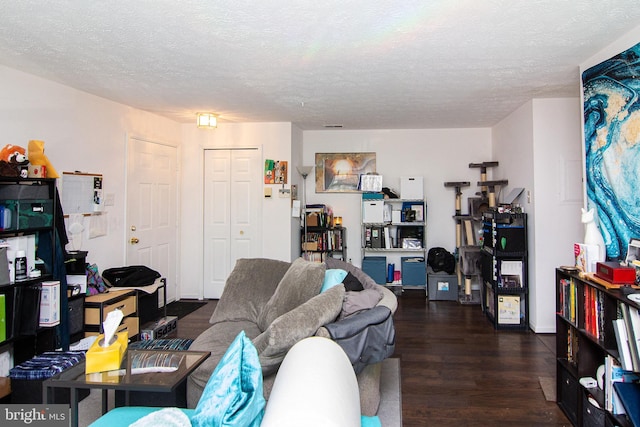 living room with dark hardwood / wood-style flooring and a textured ceiling