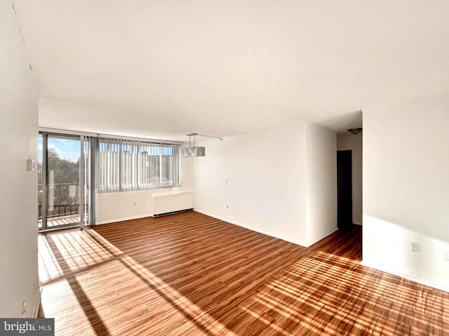 unfurnished room with wood finished floors and baseboards