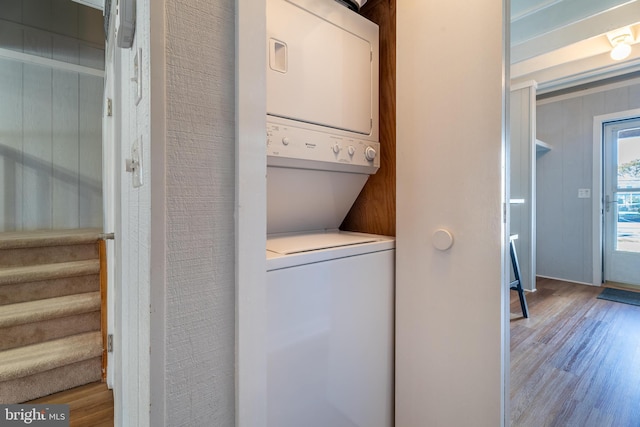 washroom with stacked washer / dryer and light hardwood / wood-style floors