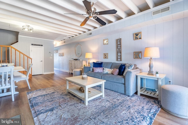 living room with beam ceiling, wood-type flooring, and ceiling fan