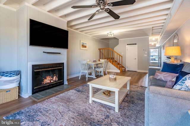 living room with beam ceiling, a fireplace, dark hardwood / wood-style floors, and ceiling fan