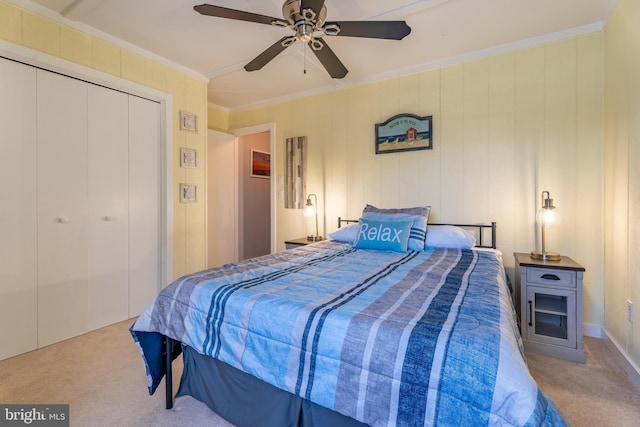 carpeted bedroom featuring ornamental molding, a closet, and ceiling fan